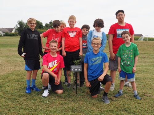 Ten students pose around the tree